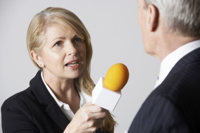 Female Journalist With Microphone Interviewing Businessman